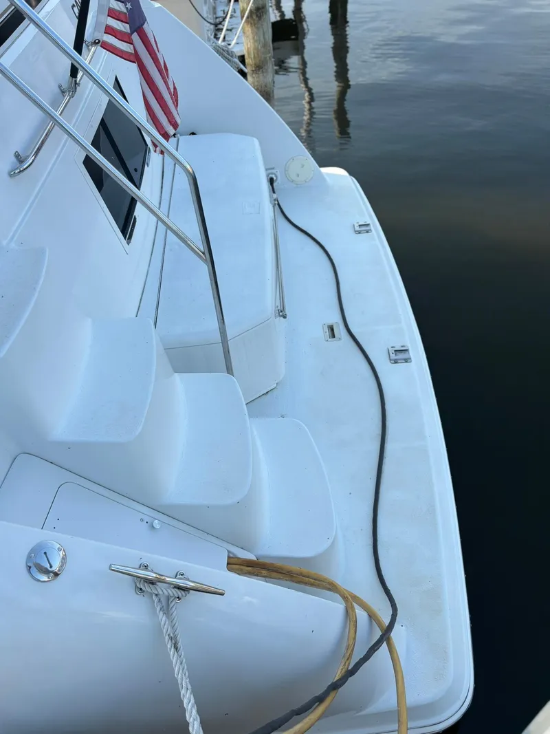 Slide: The Image of 2000 Carver 406 Aft Cabin Motor Yacht docked, showing deck and American flag. - 49