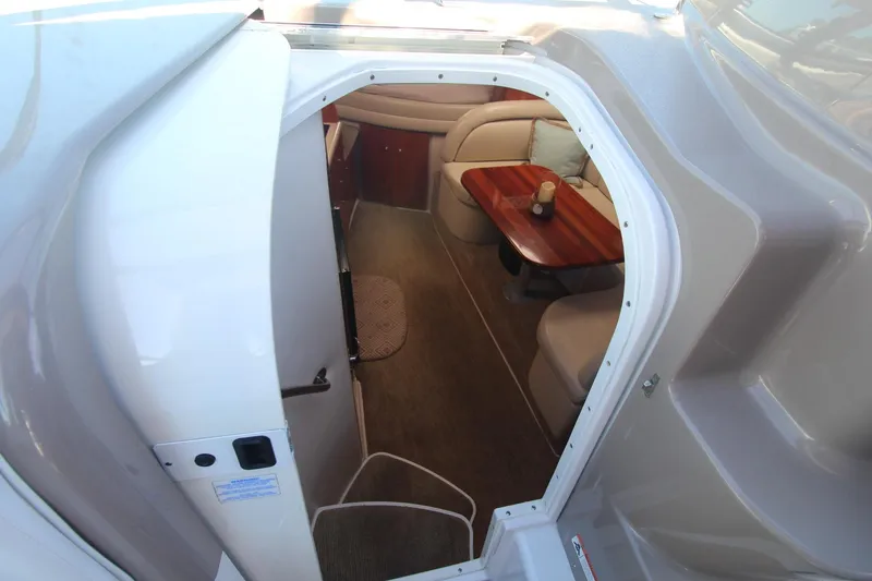 Slide: The Image of Interior view of 2004 Four Winns 348 Vista boat, featuring cozy seating and wooden table. - 15