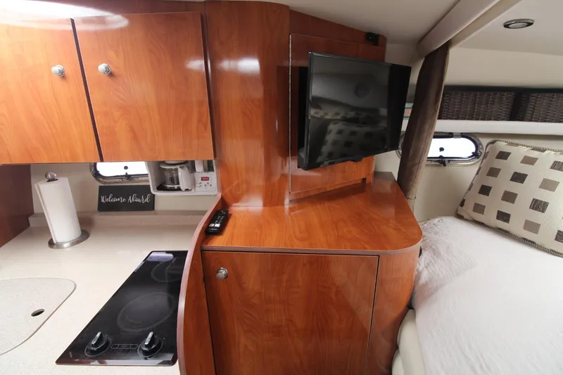 Slide: The Image of 2004 Four Winns 348 Vista interior with wood cabinetry, TV, and cozy bed. - 24