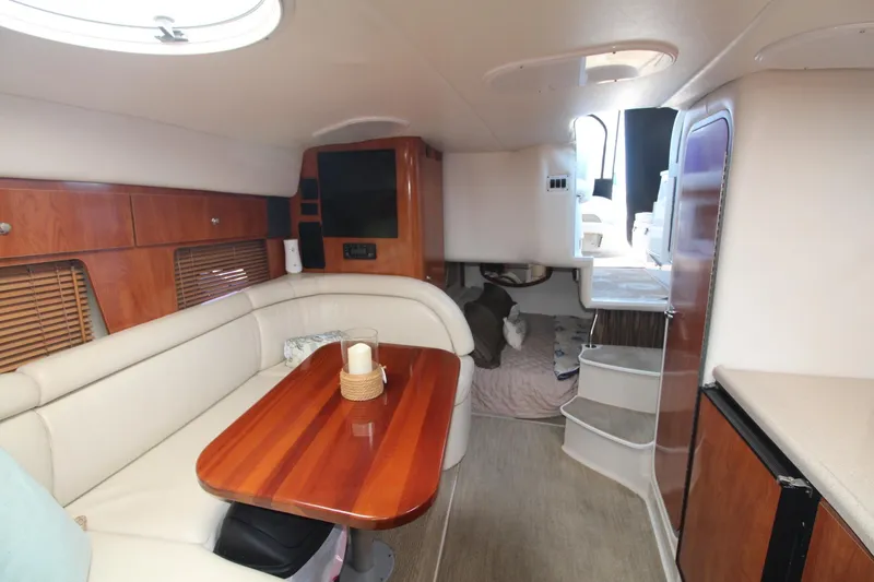 Slide: The Image of Interior of 2004 Four Winns 348 Vista yacht with cozy seating and wooden accents. - 25