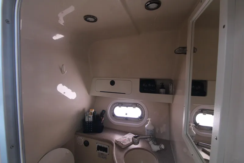 Slide: The Image of 2004 Four Winns 348 Vista boat bathroom with sink, mirror, and storage shelves. - 32