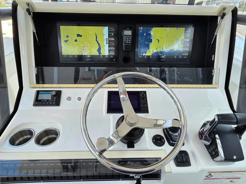 Slide: The Image of 2023 SeaVee 37 Z boat dashboard with dual navigation screens and steering wheel. - 14
