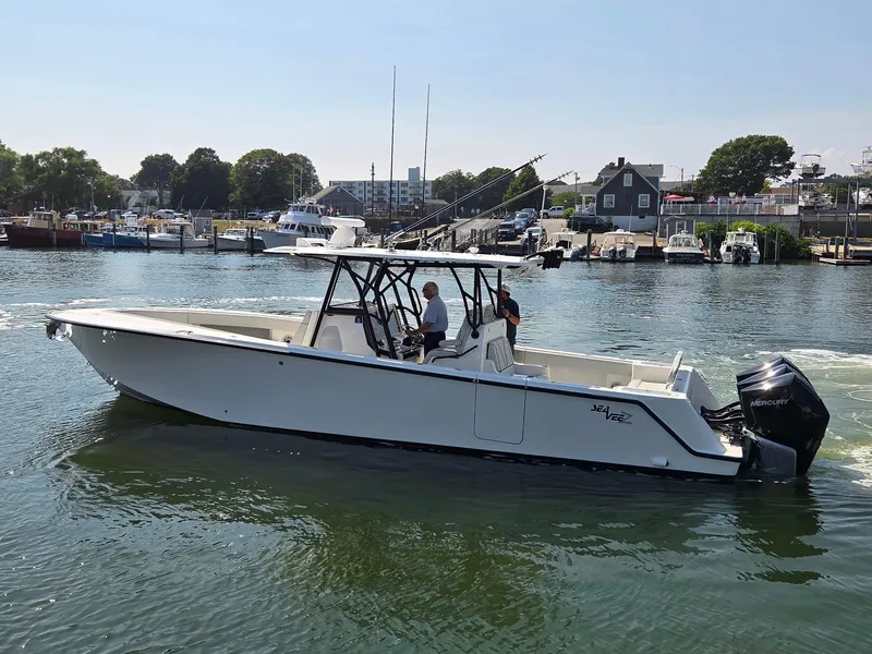 Slide: The Image of 2023 SeaVee 37 Z boat cruising in a marina with outboard engines. - 3