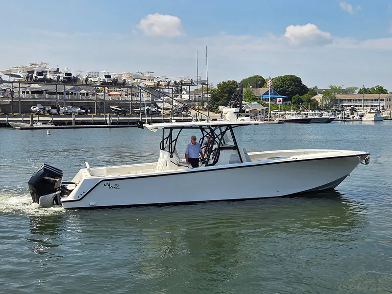 Slide: The Image of 2023 SeaVee 37 Z boat cruising in a marina with docked yachts in the background. - 4