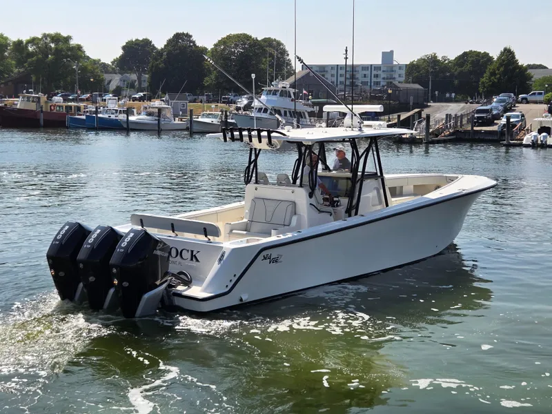 Slide: The Image of 2023 SeaVee 37 Z boat with triple Mercury engines in a marina setting. - 5