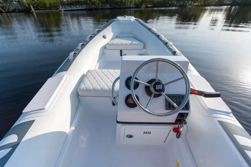 Slide: The Image of 2026 Novurania DL 400 boat interior with steering wheel on calm water. - 7