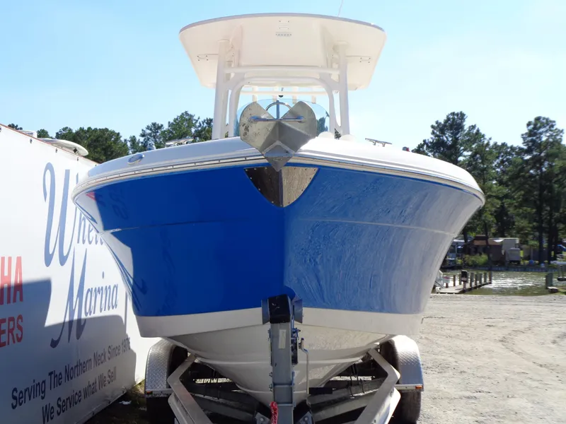 Slide: The Image of 2017 Robalo R260 Center Console boat on trailer, blue hull, outdoor marina setting. - 1