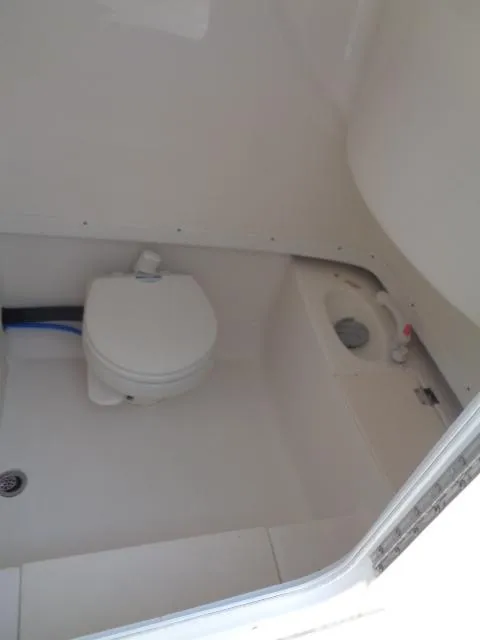 Slide: The Image of 2017 Robalo R260 Center Console boat interior with compact marine toilet. - 38