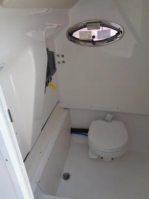 Slide: The Image of 2017 Robalo R260 Center Console boat interior with toilet and porthole window. - 39