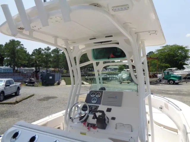 Slide: The Image of 2017 Robalo R260 Center Console boat with steering wheel and dashboard, parked outdoors. - 40