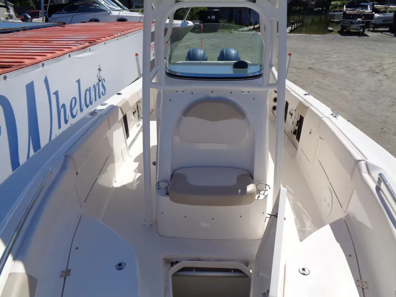 Slide: The Image of 2017 Robalo R260 Center Console boat with spacious seating and helm, docked near a marina. - 5