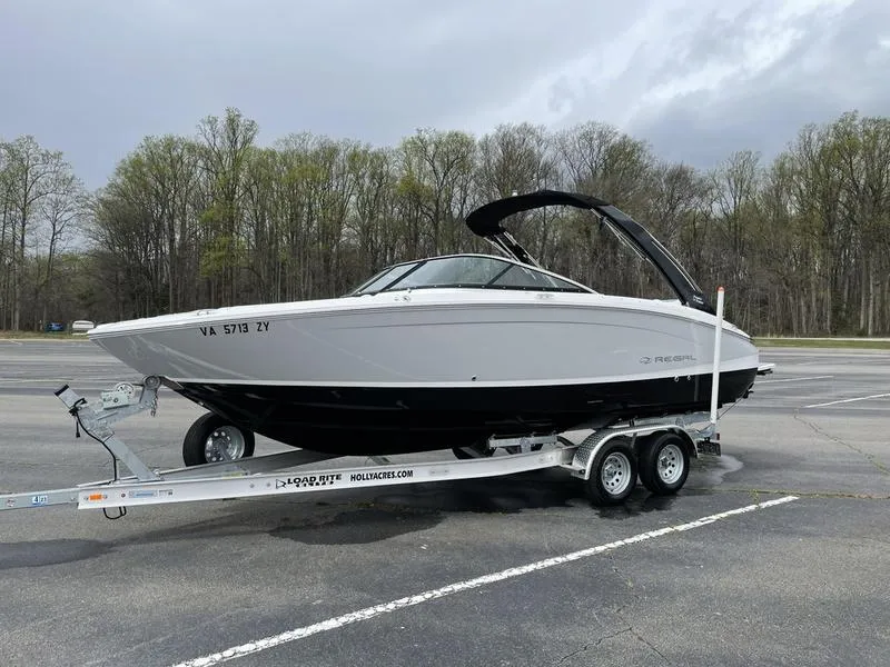 Slide: The Image of 2022 Regal LS6 boat on trailer in parking lot, overcast sky. - 2