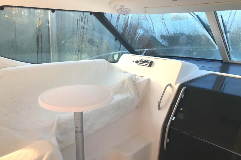 Slide: The Image of 2008 Tiara Yachts 3900 Sovran interior with covered seating and table, featuring large windows. - 29