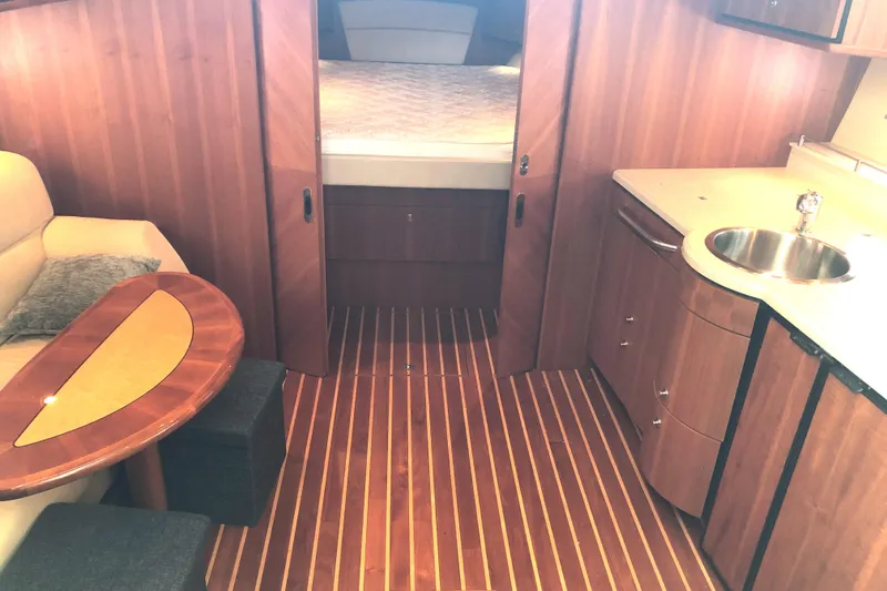 Slide: The Image of 2008 Tiara Yachts 3900 Sovran interior with wood flooring, kitchenette, and cozy seating area. - 39