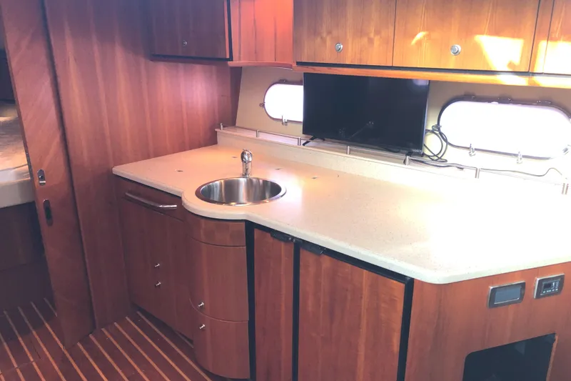 Slide: The Image of 2008 Tiara Yachts 3900 Sovran interior kitchen with wood cabinetry and countertop sink. - 40