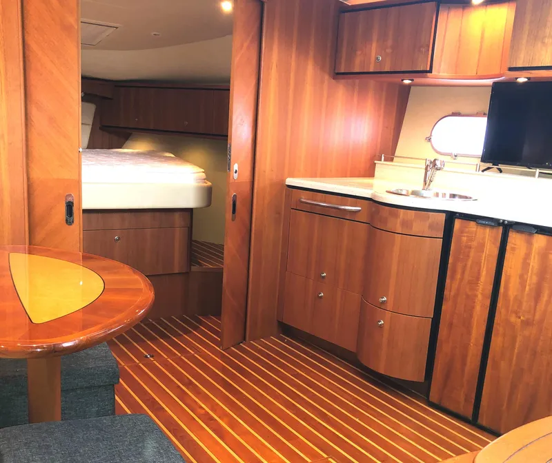 Slide: The Image of 2008 Tiara Yachts 3900 Sovran interior with wood finish, kitchenette, and cozy sleeping area. - 41