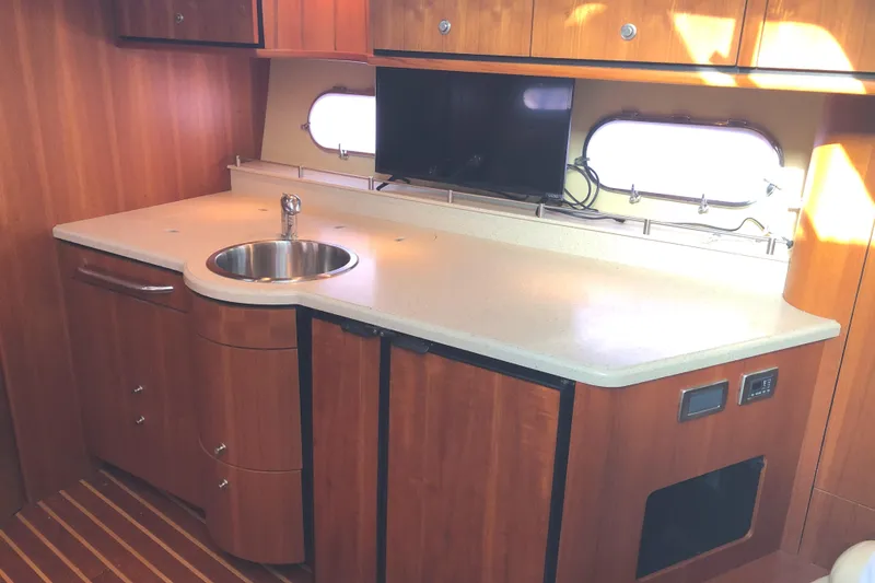 Slide: The Image of 2008 Tiara Yachts 3900 Sovran interior kitchen with sink, wooden cabinets, and countertop. - 43