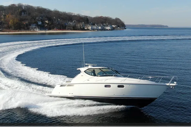 Slide: The Image of 2008 Tiara Yachts 3900 Sovran cruising on open water near a coastal town. - 7