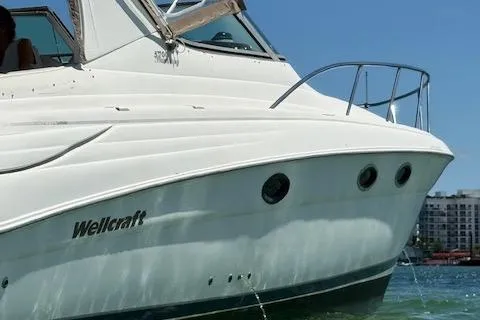 Slide: The Image of 2001 Wellcraft Martinique 3700 boat on water, showcasing sleek design and white exterior. - 13