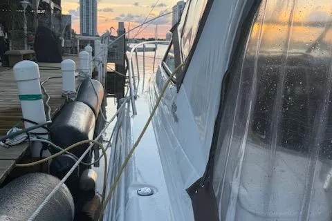 Slide: The Image of 2001 Wellcraft Martinique 3700 docked at sunset, with city skyline in background. - 16
