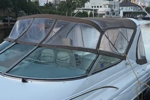 Slide: The Image of 2001 Wellcraft Martinique 3700 boat with brown canopy docked by the water. - 19