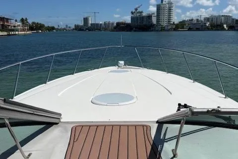 Slide: The Image of 2001 Wellcraft Martinique 3700 yacht cruising on a scenic waterway with city skyline. - 21