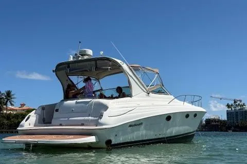Slide: The Image of 2001 Wellcraft Martinique 3700 yacht on water, sunny day, people onboard, palm trees in background. - 8
