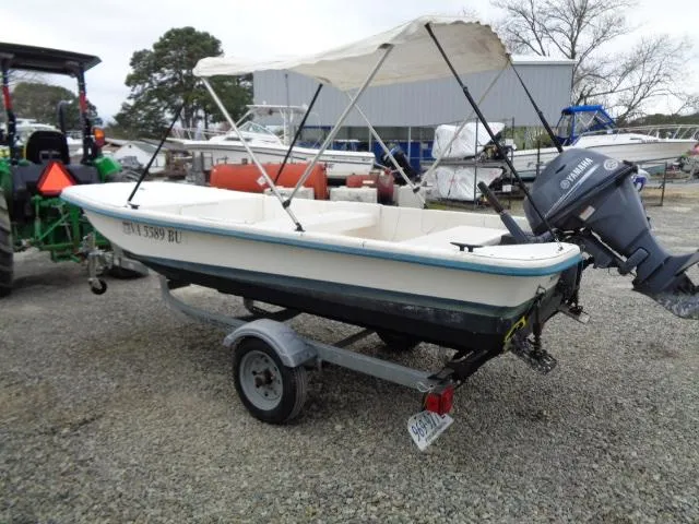 Slide: The Image of 2010 Sundance K14T boat with Yamaha motor on trailer, parked outdoors. - 3