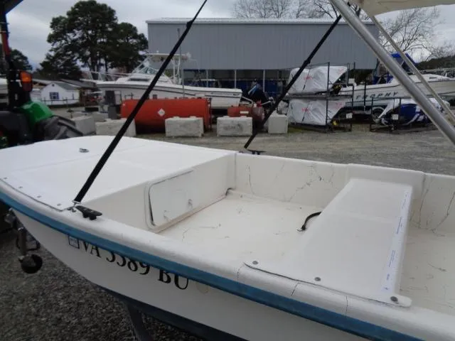 Slide: The Image of 2010 Sundance K14T boat in a marina, white hull, open deck, parked outdoors. - 6