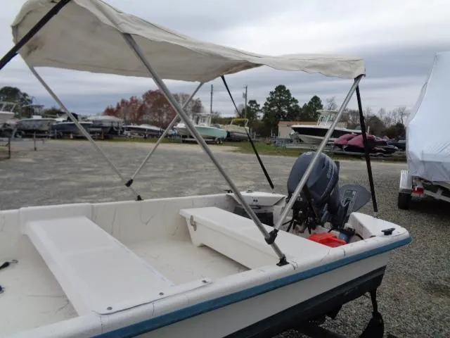 Slide: The Image of 2010 Sundance K14T boat with canopy and outboard motor in a boatyard. - 7