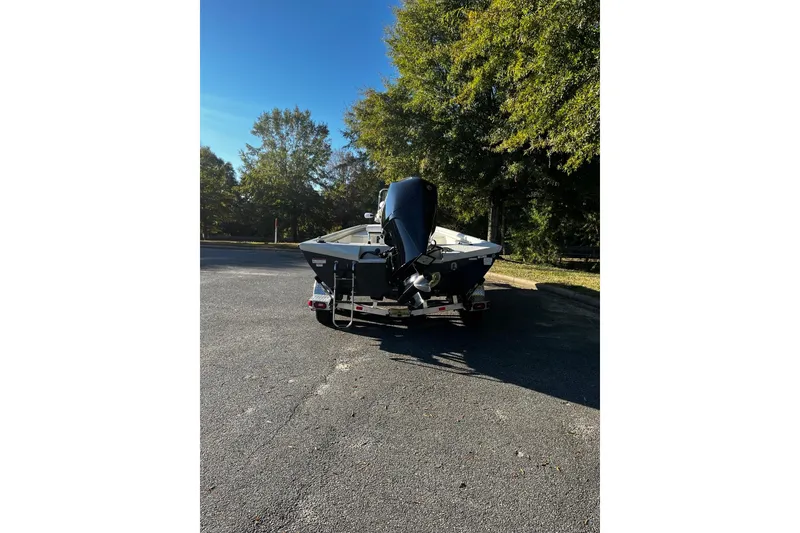 Slide: The Image of 2025 Ranger RB210 boat on trailer, parked outdoors with trees in the background. - 3