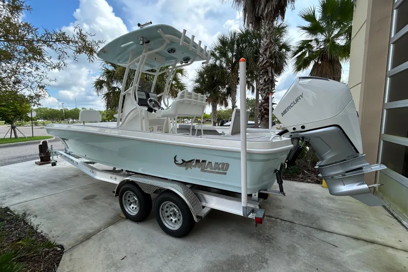 Slide: The Image of 2025 Mako 24 APEX boat on trailer, featuring Mercury outboard motor, parked outdoors. - 3