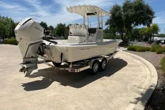 Slide: The Image of 2025 Ranger 2510 Bay boat on trailer, parked outdoors under clear sky. - 3