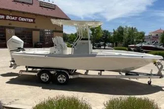 Slide: The Image of 2025 Ranger 2510 Bay boat on trailer outside a boat center. - 2
