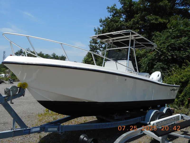Slide: The Image of 1992 Mako 22 CC boat on trailer, sunny day, trees in background. - 2