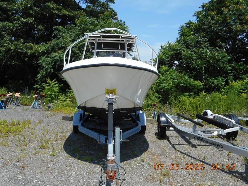Slide: The Image of 1992 Mako 22 CC boat on trailer, surrounded by greenery. - 3