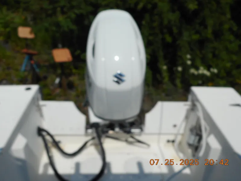 Slide: The Image of Blurry image of a Suzuki outboard motor on a 1992 Mako 22 CC boat. - 5