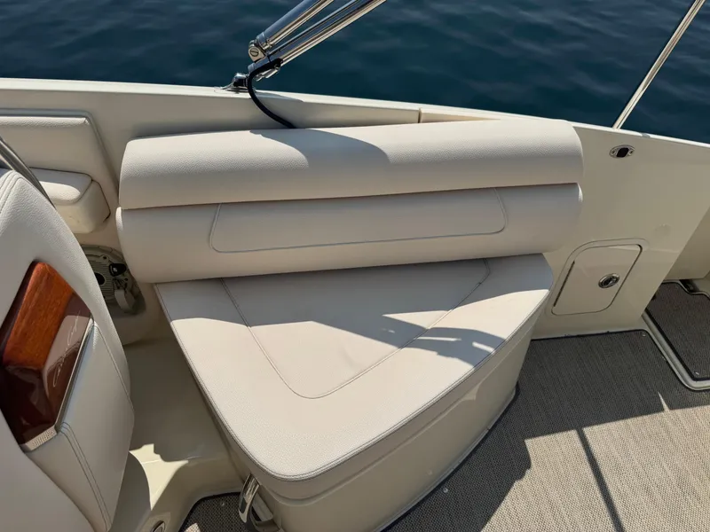 Slide: The Image of 2022 Chris-Craft Launch 28 GT boat interior with beige seating and wood accents. - 16