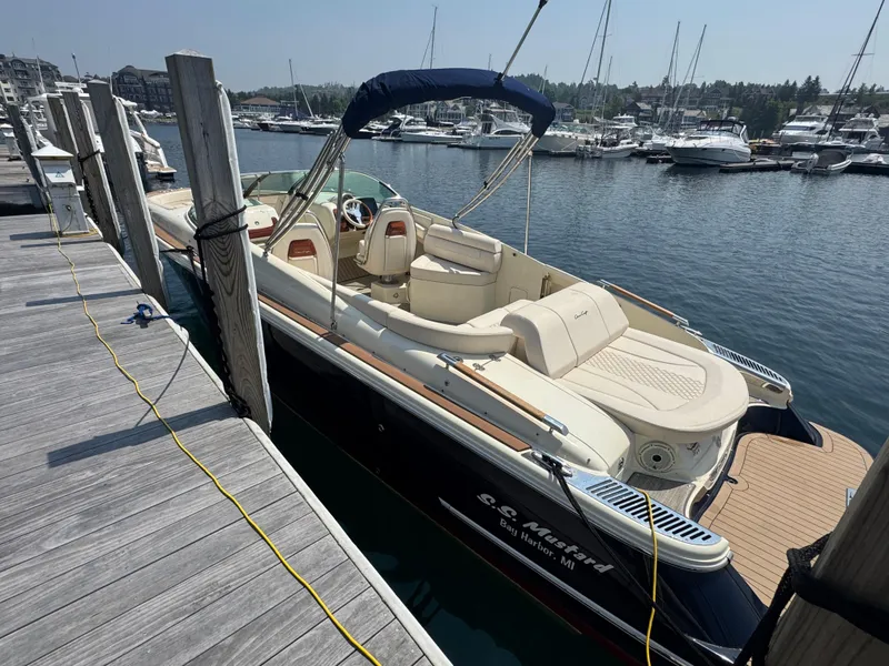 Slide: The Image of 2022 Chris-Craft Launch 28 GT docked at marina, featuring elegant design and spacious seating. - 2