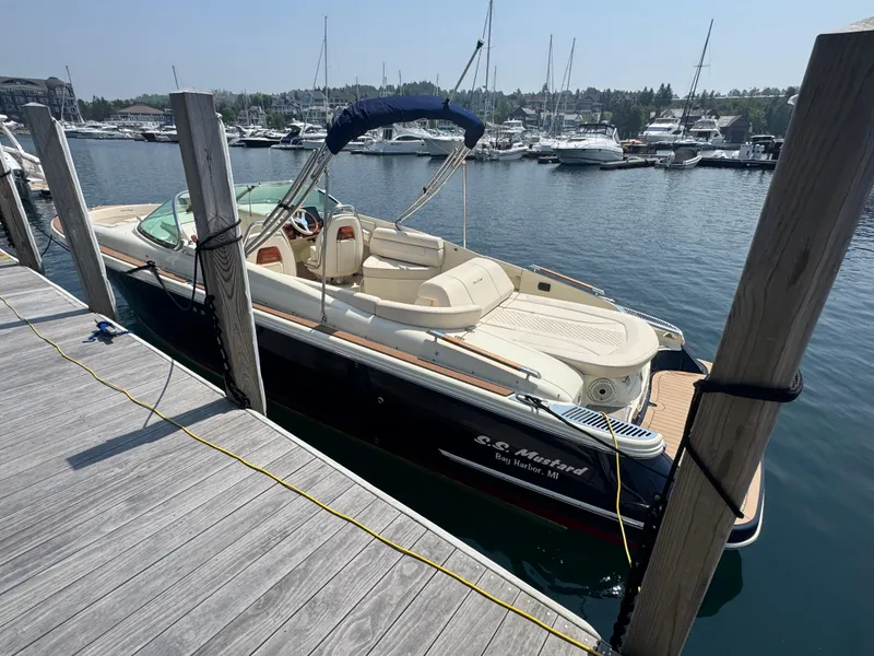 Slide: The Image of 2022 Chris-Craft Launch 28 GT docked at a marina, featuring elegant design and spacious seating. - 5