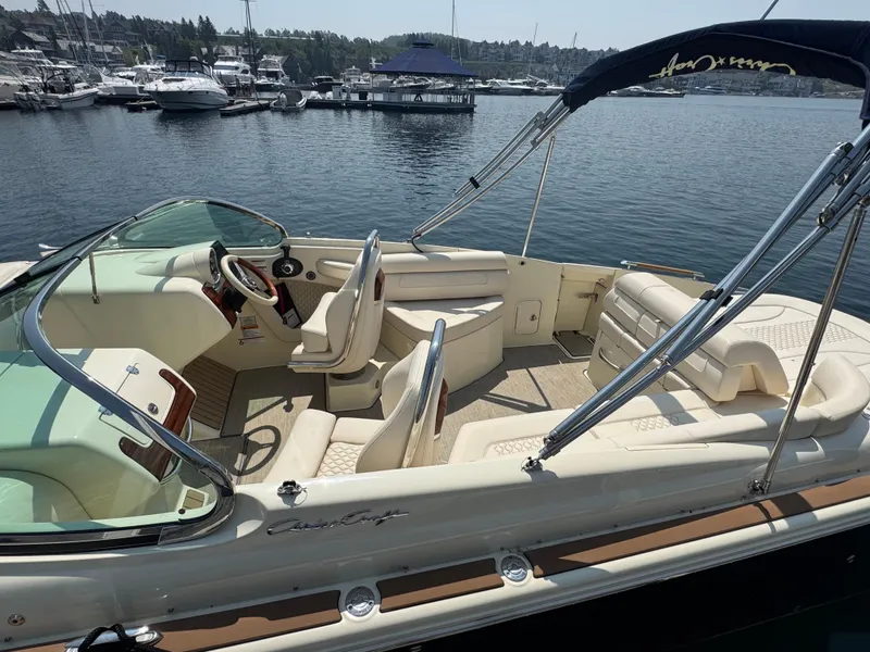 Slide: The Image of 2022 Chris-Craft Launch 28 GT boat interior at marina, showcasing luxury seating and helm. - 6