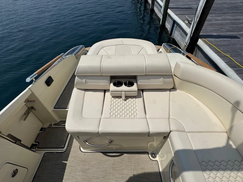 Slide: The Image of 2022 Chris-Craft Launch 28 GT boat interior with beige seating and cup holders by the dock. - 8