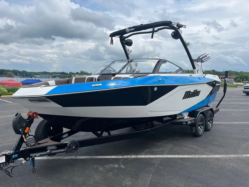The Image of 2025 Malibu Wakesetter 23 LSV boat on trailer, blue and white design, parked outdoors. - 1