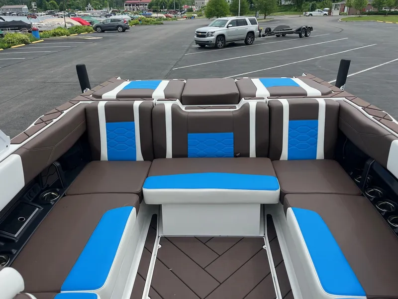 Slide: The Image of 2025 Malibu Wakesetter 23 LSV interior with brown and blue seating in a parking lot. - 11
