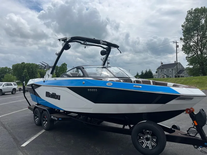 Slide: The Image of 2025 Malibu Wakesetter 23 LSV boat on trailer, parked outdoors under cloudy sky. - 7