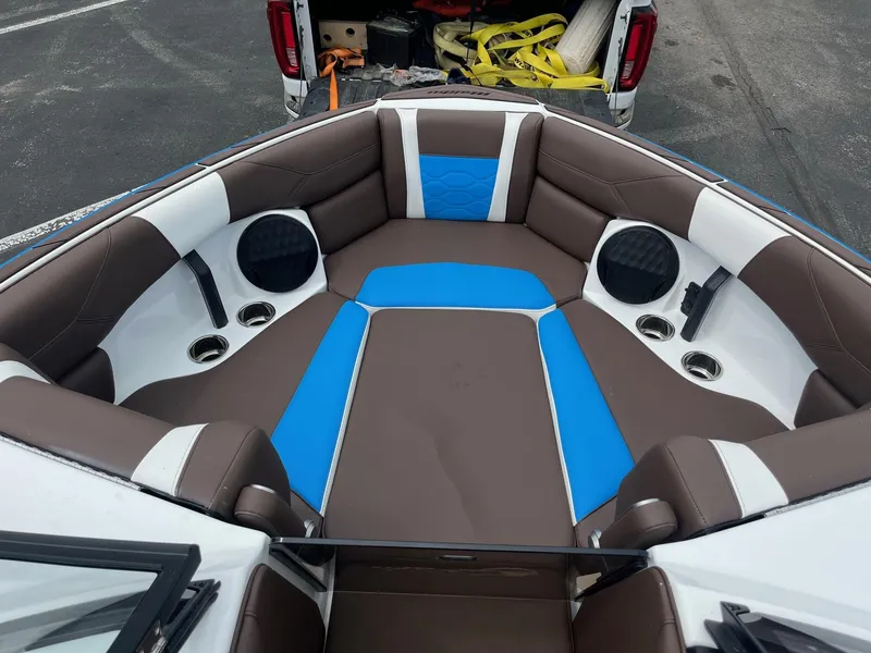 Slide: The Image of 2025 Malibu Wakesetter 23 LSV interior with brown and blue seating, cup holders, and speakers. - 8