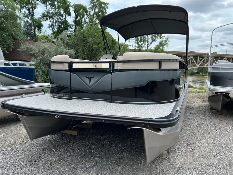 The Image of 2026 Tahoe Pontoon SPORT 85 2385 CRUISE on gravel near river and trees. - 1