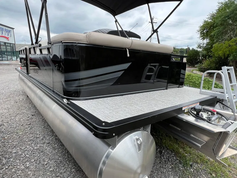 Slide: The Image of 2026 Tahoe Pontoon SPORT 85 2385 CRUISE, sleek black design, parked on gravel. - 4