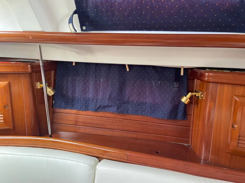 Slide: The Image of Interior of 2003 Beneteau 423 yacht with wooden cabinetry and blue curtains. - 10
