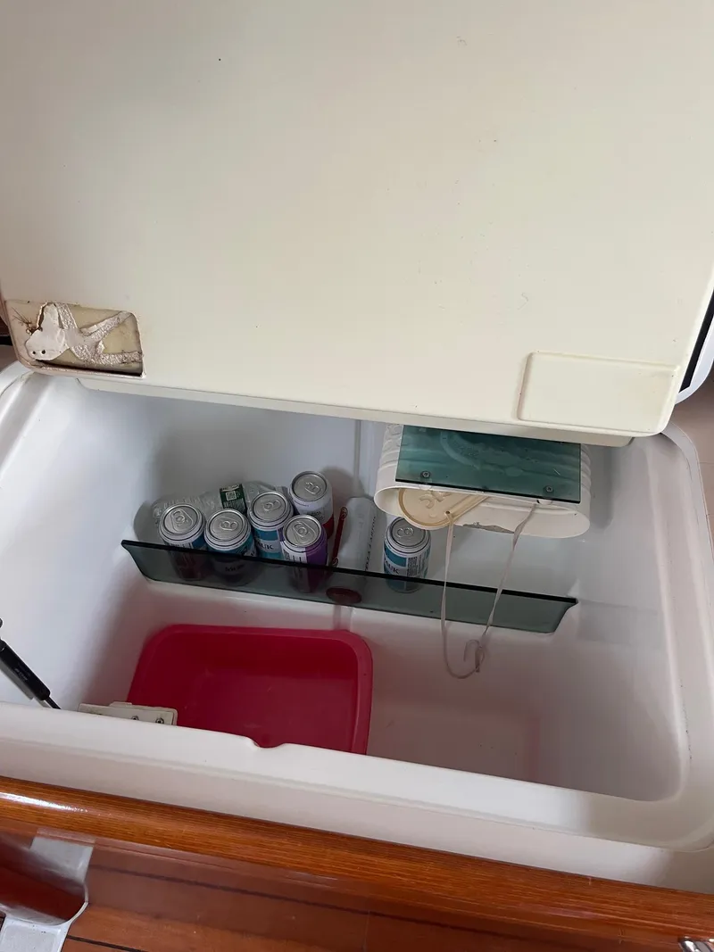 Slide: The Image of Open cooler on a 2003 Beneteau 423 yacht, containing canned drinks and a pink container. - 13